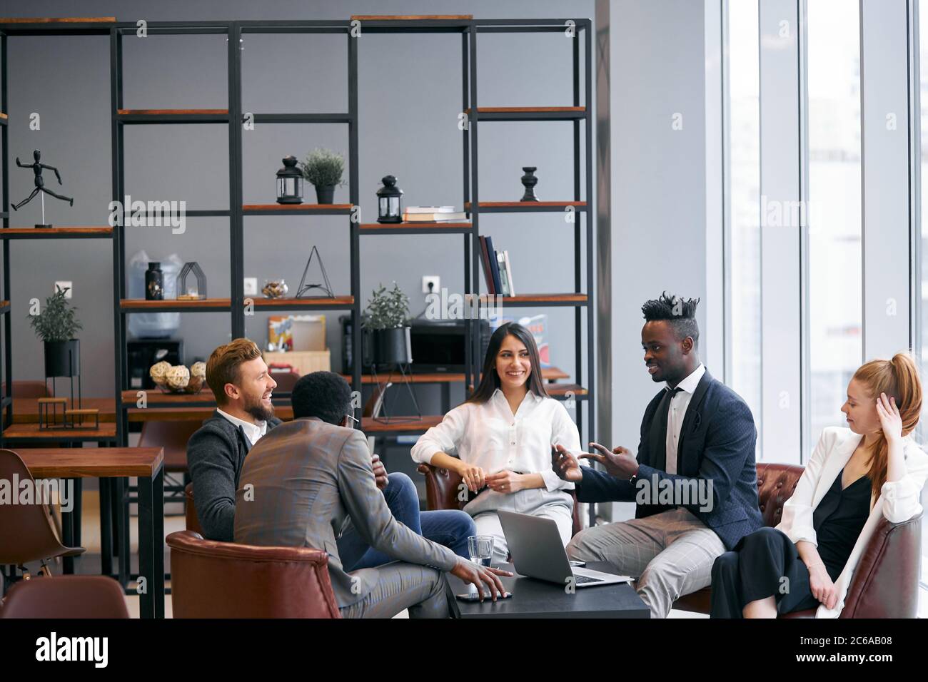 Selbstbewusste Geschäftspartner trafen sich im Büro, um interessante gemeinsame Geschäftsideen zu diskutieren und Geschäftsideen auszutauschen Stockfoto