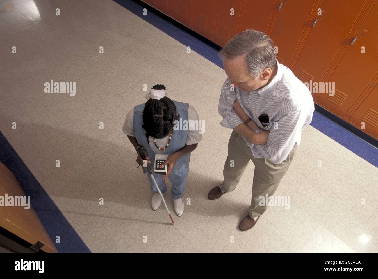 Austin, Texas, USA, 2002: Blinde Schülerin verwendet Infrarot-Guide-Geräte, um sich an der Texas School for the Blind zurechtzufinden, während der Lehrer zuschaut. ©Bob Daemmrich Stockfoto