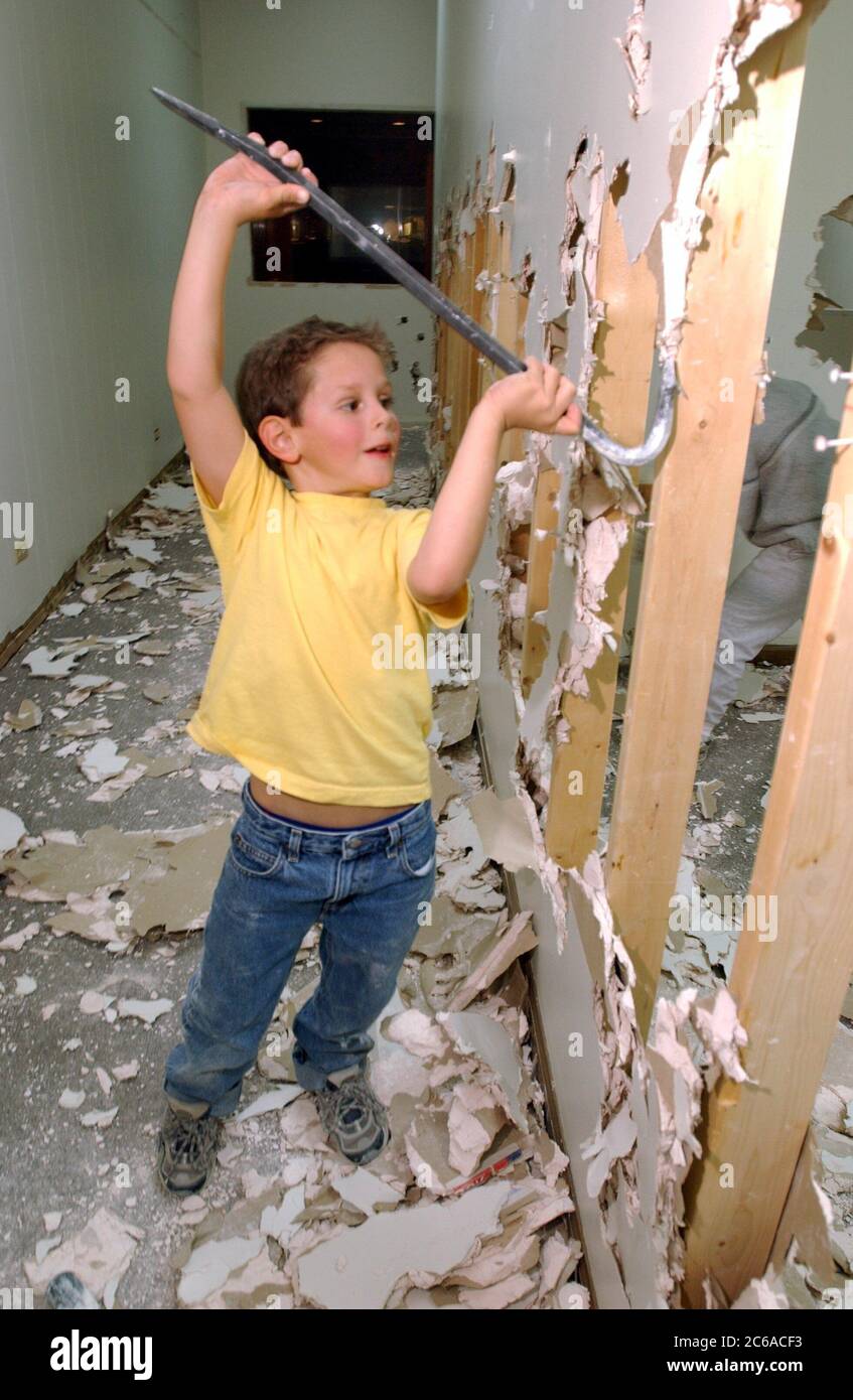 Austin Texas, USA, 2003: Ein sechsjähriger Junge benutzt Brechstange, um beim Umbau der Trockenbauwand zu helfen. Modell Freigegeben. HERR ©Bob Daemmrich Stockfoto