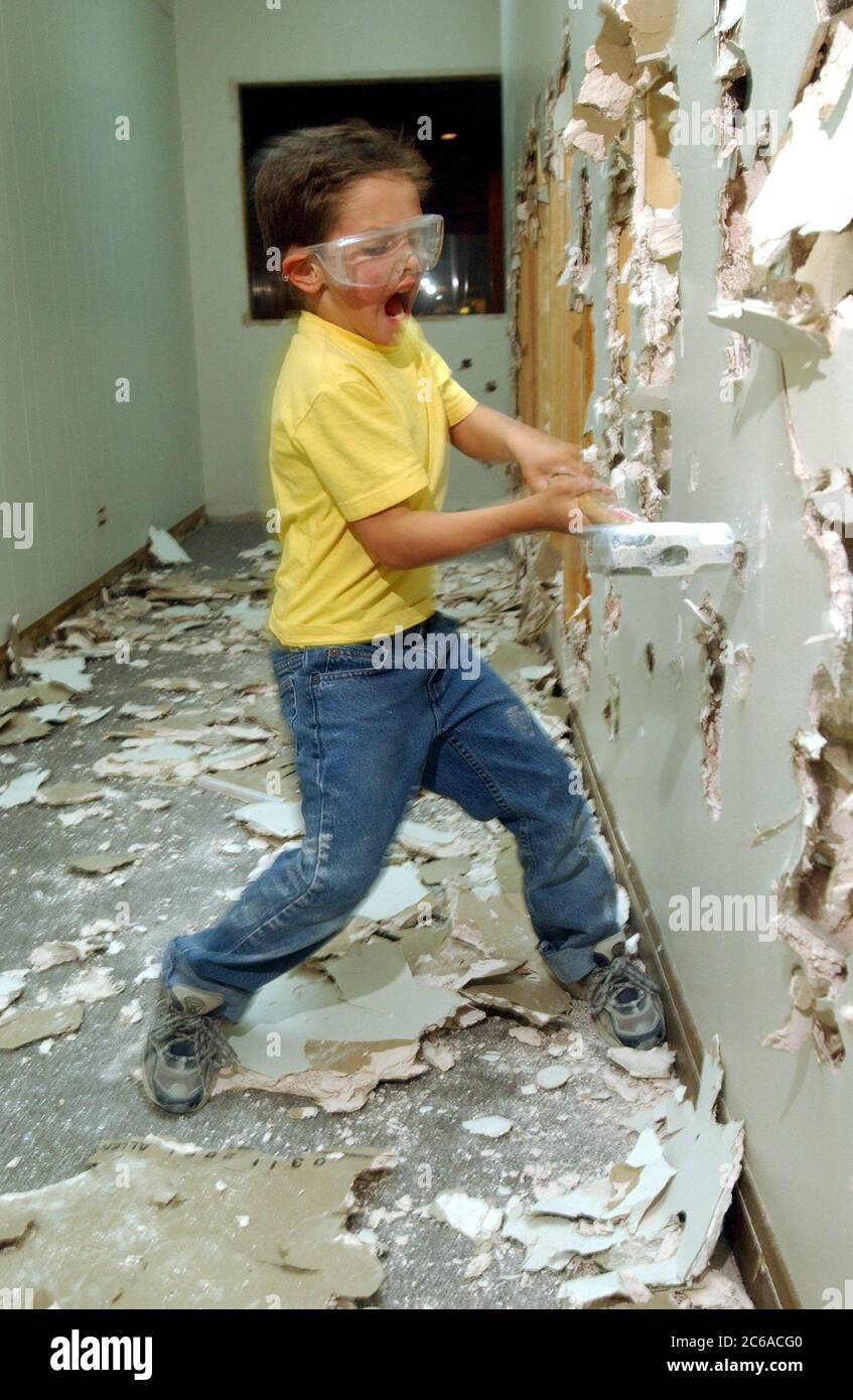 Austin Texas, USA, 2003: Ein sechsjähriger Junge mit Schutzbrille verwendet einen Vorschlaghammer, um beim Umbau von Trockenbauwänden zu helfen. Modell Freigegeben. HERR ©Bob Daemmrich Stockfoto