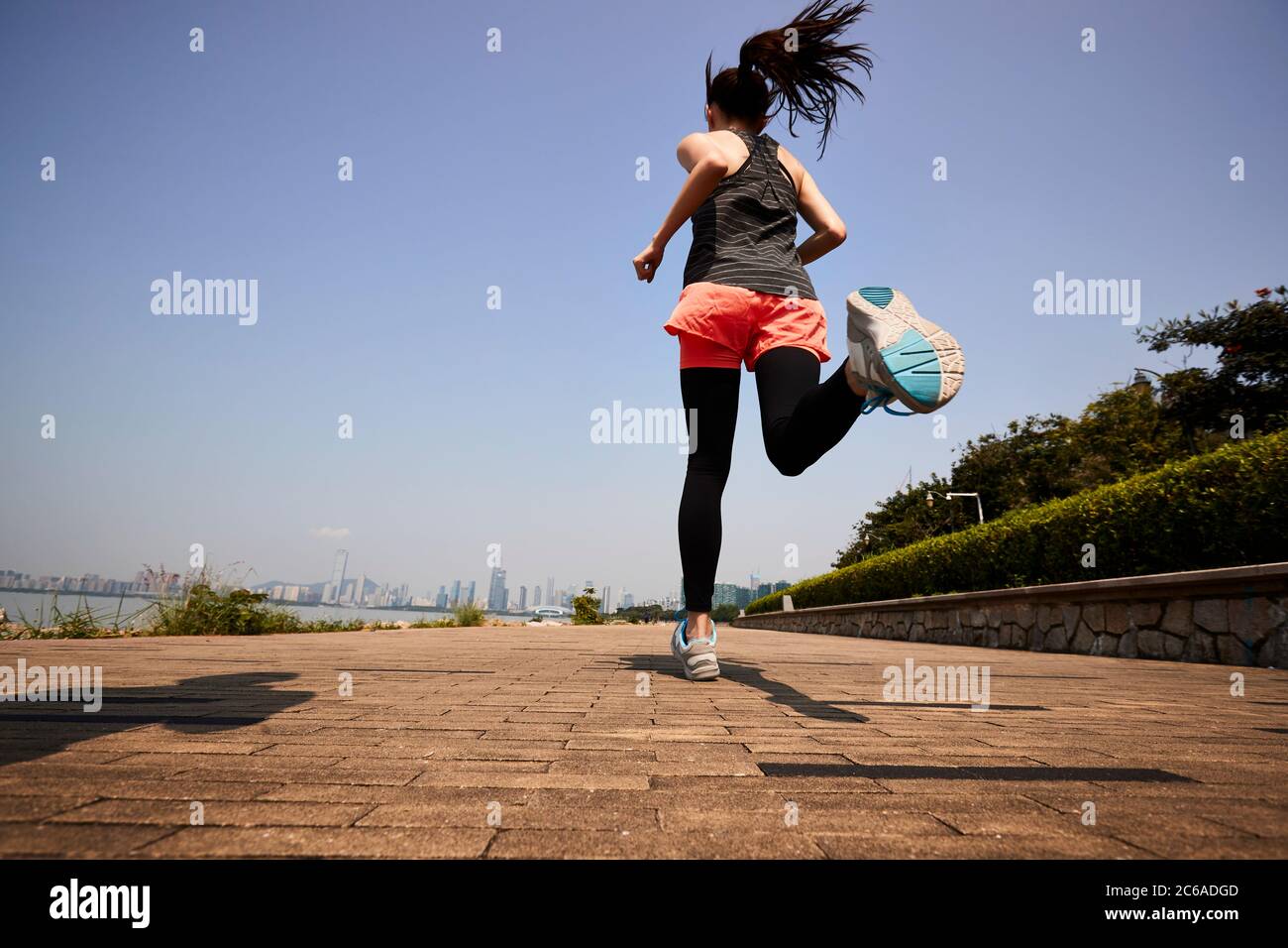 Junge asiatische Erwachsene Frau Joggen im Freien, hinten und niedrigen Winkel Ansicht Stockfoto