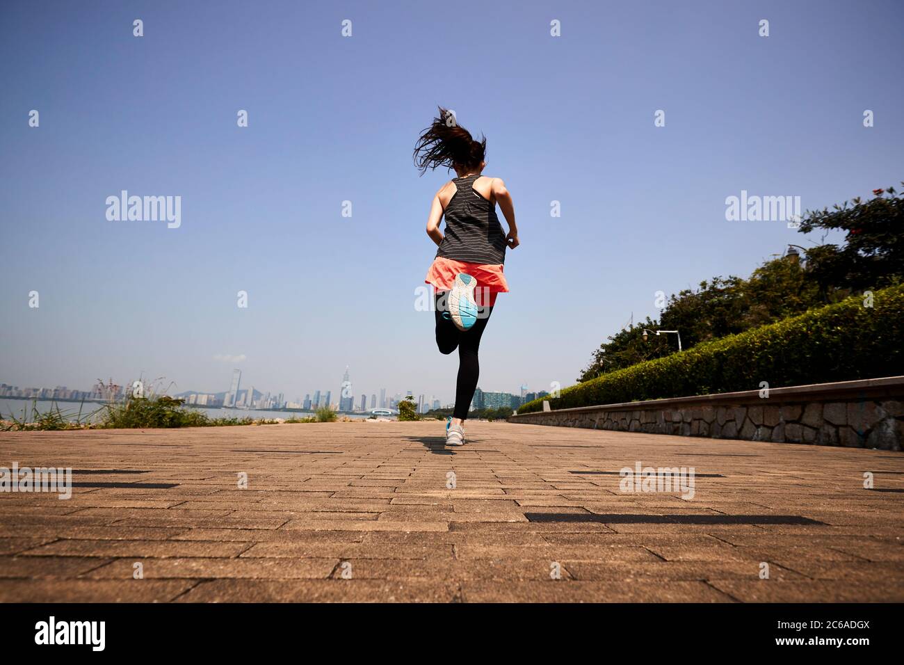 Junge asiatische Erwachsene Frau Joggen im Freien, hinten und niedrigen Winkel Ansicht Stockfoto