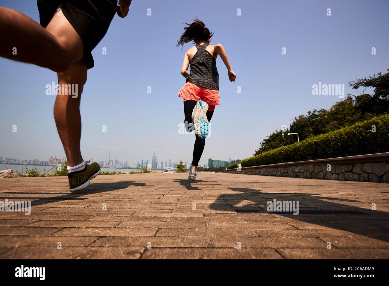 Drei junge asiatische Erwachsene joggen im Freien, hinten und in der unteren Winkel Ansicht Stockfoto