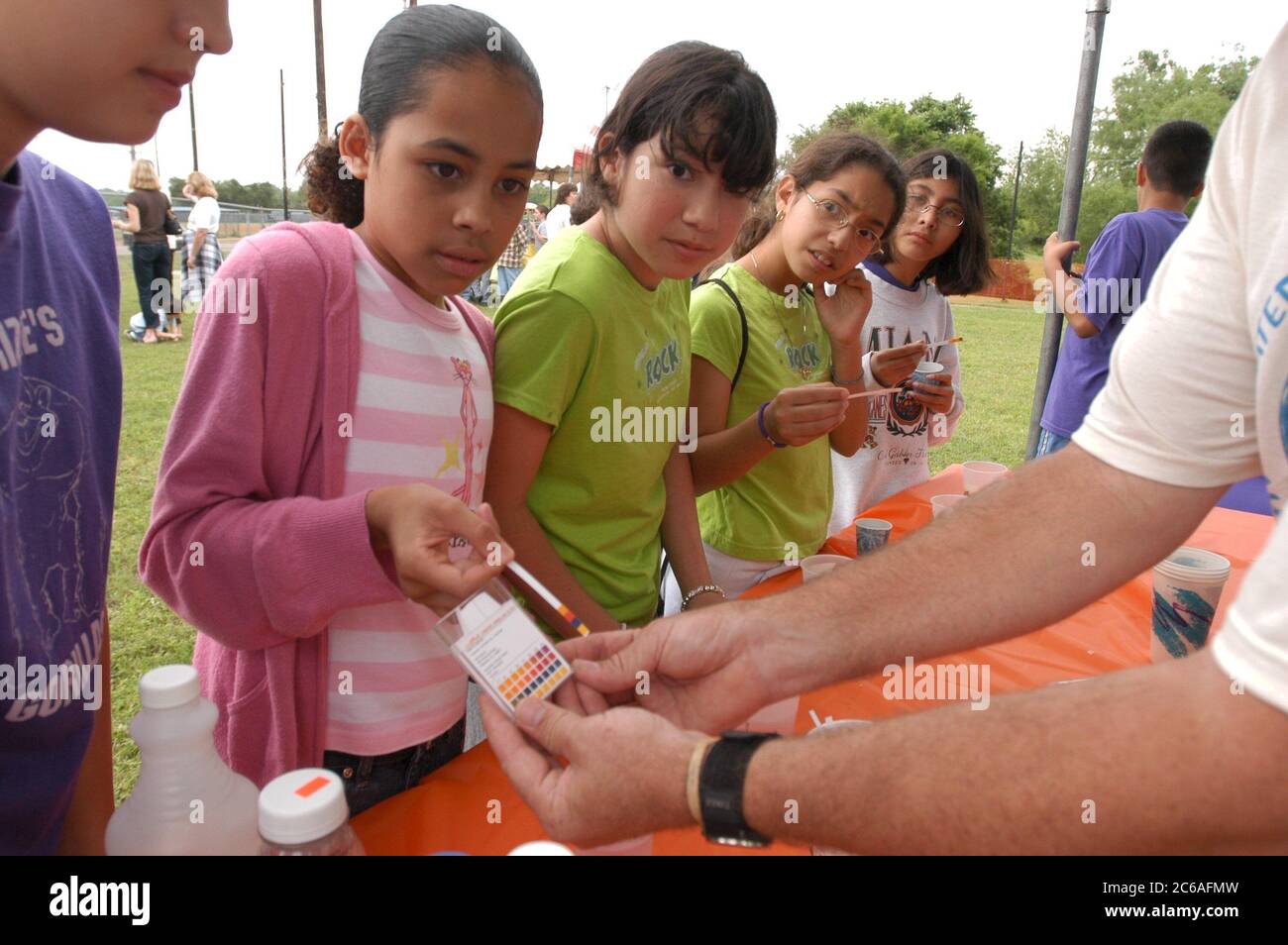 Austin Texas, USA, April 2004: Schüler der 6. Und 7. Klasse erfahren auf der von der City of Austin gesponserten Outdoor-Veranstaltung Blue Thumb mehr über Wasser- und Abwasserprobleme. Hispanische Studenten testen den pH-Wert verschiedener Flüssigkeiten mit Lackmuspapier. ©Bob Daemmrich Stockfoto