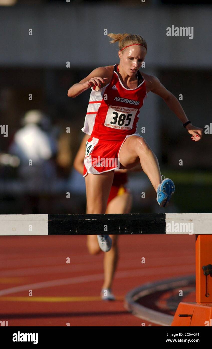 Austin Texas, USA, Juni 2004: Weiße Sportlerinnen überspringen eine Hürde während der Steeplechase-Veranstaltung der National Collegiate Athletic Association (NCAA) Division I Outdoor Track & Field Championships. ©Bob Daemmrich Stockfoto
