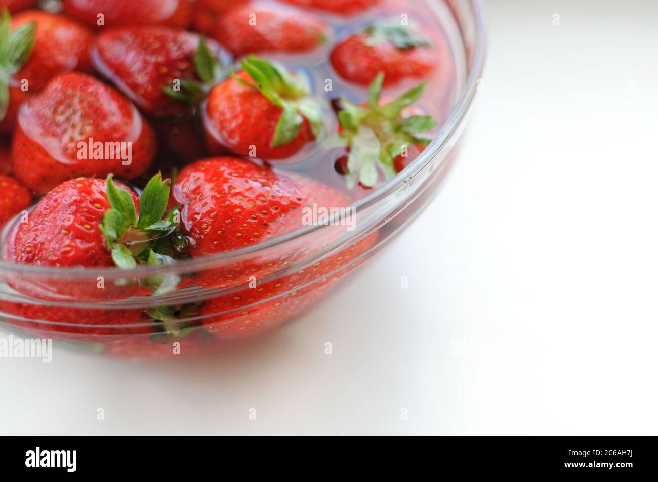 Nahaufnahme mit Kopierraum von Home Erdbeere in Schüssel mit Wasser. Vitamine für den Sommer. Stockfoto