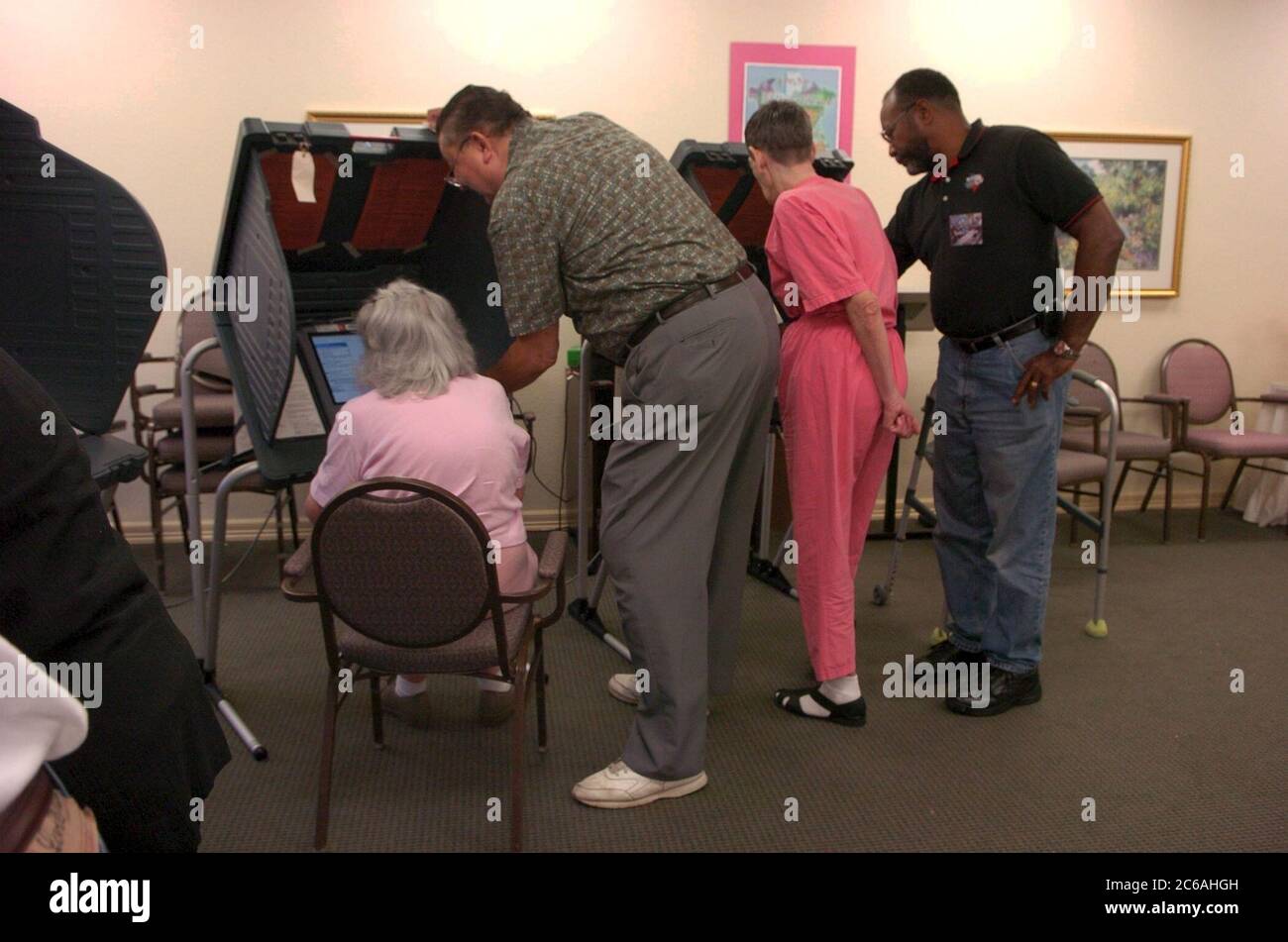 Austin, Texas, USA, Oktober 19 2004: Eine frühe Wählerin, die Hilfe braucht, sitzt in einem Stuhl vor einem elektronischen Wahlgerät, während sie bei den Parlamentswahlen im November 2 in einer Senioreneinrichtung ihre Stimme abgibt. ©Bob Daemmrich Stockfoto