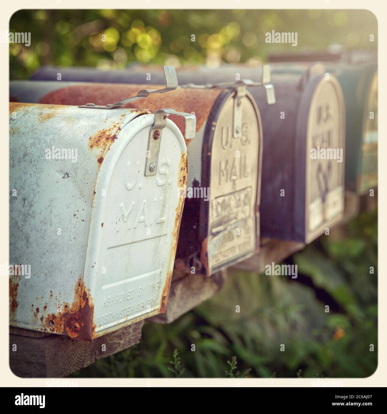 Verrostete US-Briefkästen in der Nachmittagssonne. Instagram-Style-Verarbeitung. Gefiltert, um wie ein veraltertes Sofortfoto zu aussehen. Stockfoto