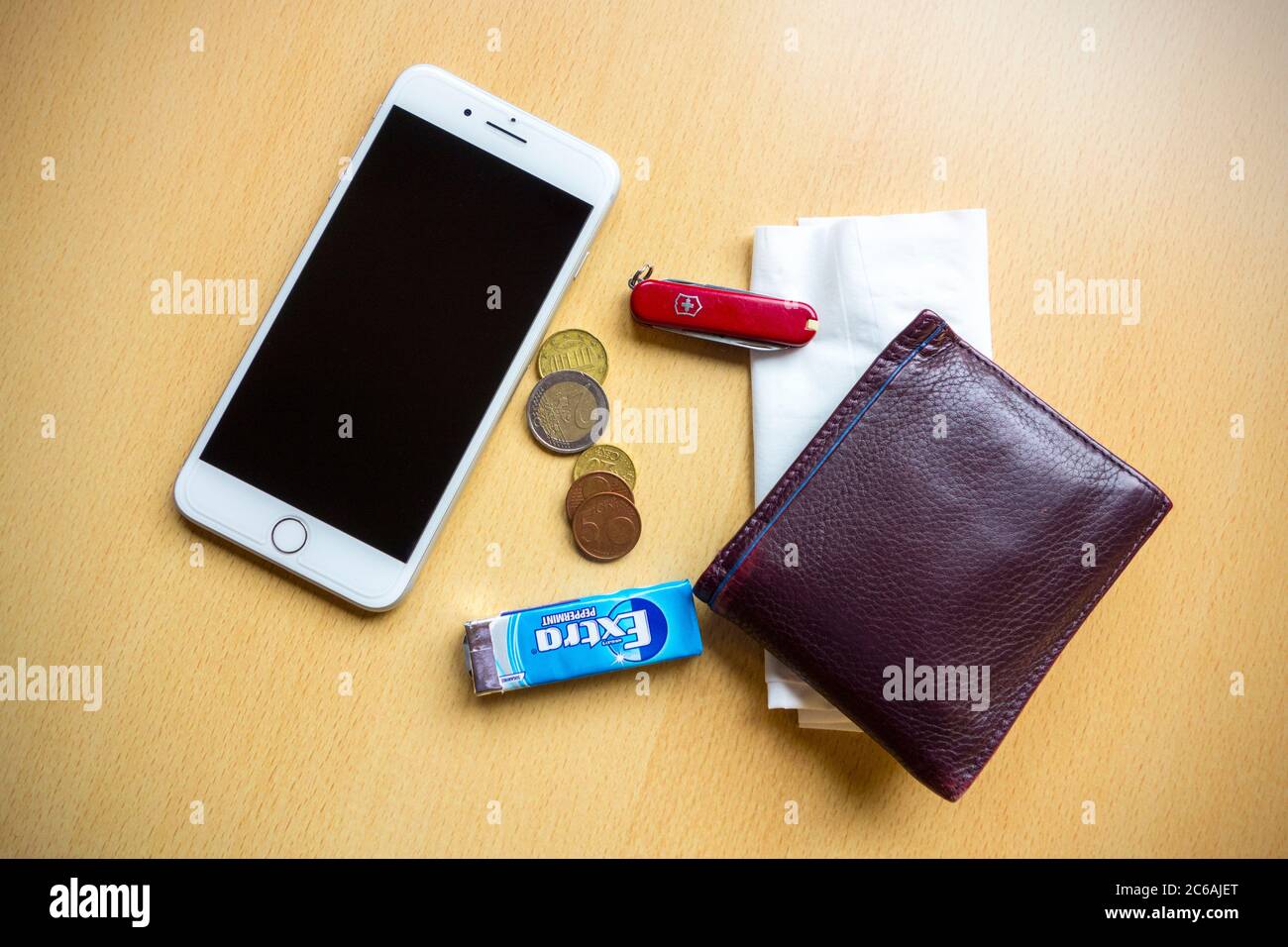 Typische Inhalte von Taschen, Geldbörse, Telefon, Taschentuch, Kaugummi, Taschenmesser und Münzen eines Mannes Stockfoto