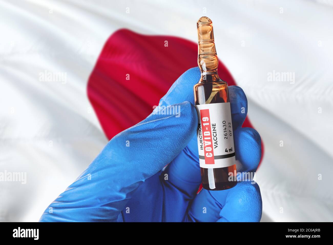 Japan Flagge mit Coronavirus Covid-19 Konzept. Arzt mit blauen Schutz medizinische Handschuhe hält eine Impfstoffflasche. Coronavirus covid 19 Impfstoffforschung Stockfoto