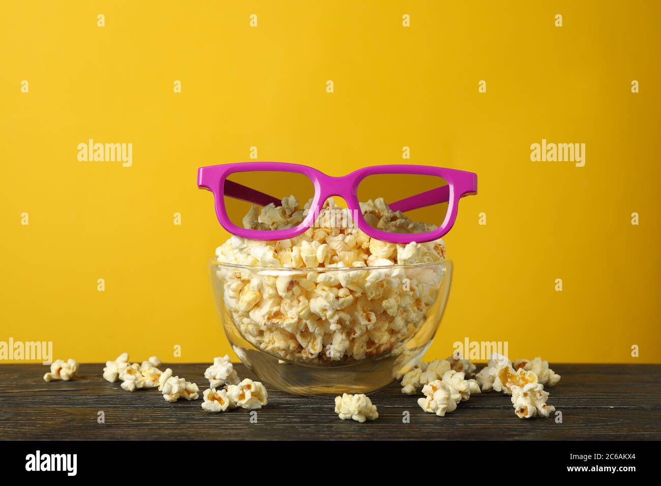 Schüssel mit Popcorn und 3d-Brille auf Holztisch. Essen zum Kino schauen Stockfoto