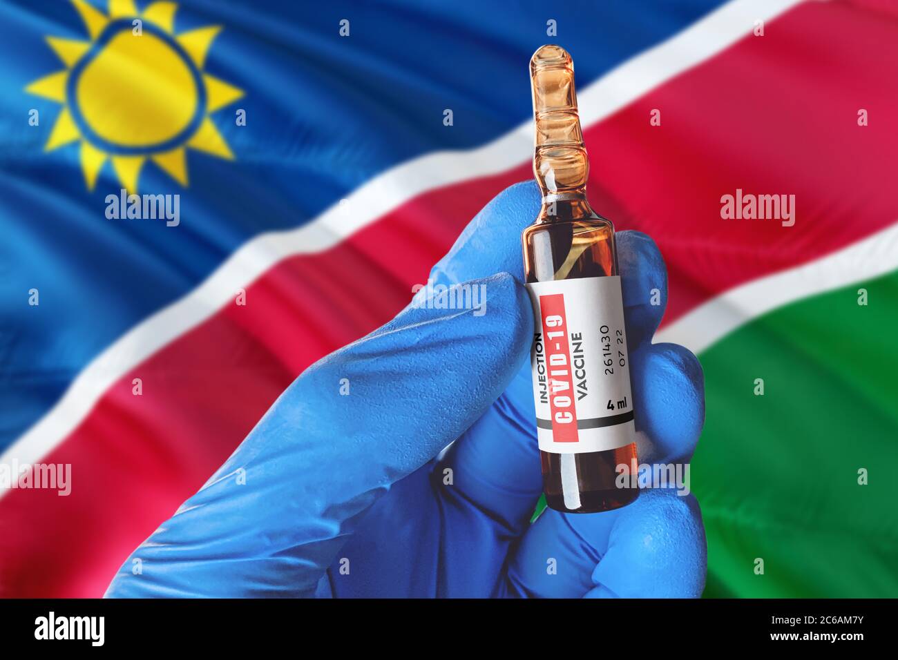 Namibia Flagge mit Coronavirus Covid-19 Konzept. Arzt mit blauen Schutz medizinische Handschuhe hält eine Impfstoffflasche. Coronavirus covid 19 Impfstoff resear Stockfoto
