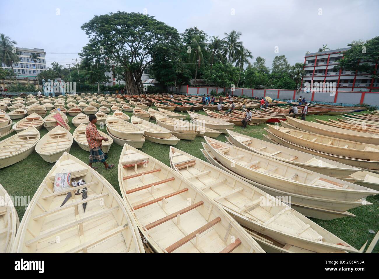 Ghior, Manikgan, Bangladesch. Juli 2020. Handgefertigte Holzboote werden am 08. Juli 2020 auf einem Markt in Ghior, Manikgan, Bangladesch, zum Verkauf angeboten. Die Nachfrage nach verschiedenen Arten von kleinen Booten ist hier mit dem Anstieg des Wasserpegels in verschiedenen Flüssen und den anschließenden Überschwemmungen gestiegen. Die Nachfrage nach Dingi und Khosa Nauka (Kleinboot) hat sich für die regelmäßige Bewegung von Menschen in flutgefährdeten Gebieten hier erhöht. Quelle: Suvra Kanti das/ZUMA Wire/Alamy Live News Stockfoto