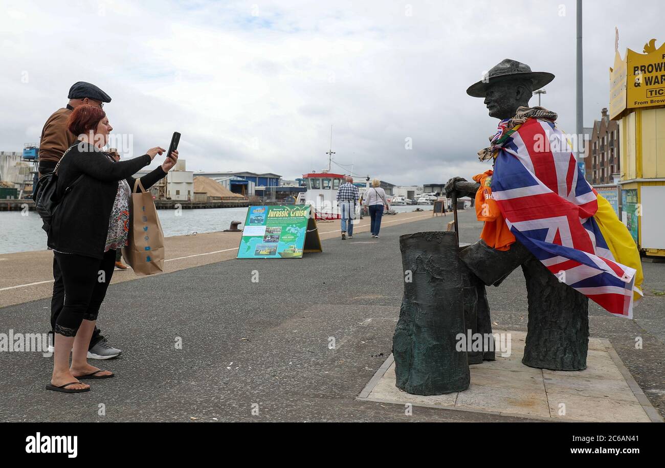 Die Menschen fotografieren die Statue von Robert Baden-Powell am Kai von Poole, Dorset, nachdem der gemeinderat den Schutzhorten um sie entfernt hatte, der im vergangenen Monat errichtet wurde, nachdem die Demonstranten von Black Lives Matter in Bristol eine Statue des Sklavenhändlers Edward Colston niedergerissen hatten. Stockfoto