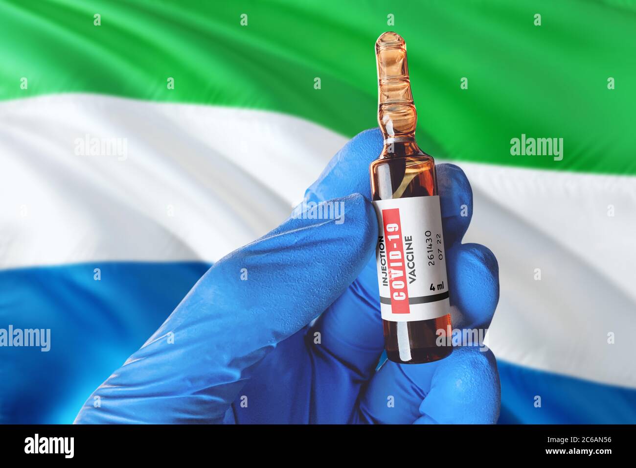 Flagge Sierra Leones mit Coronavirus Covid-19 Konzept. Arzt mit blauen Schutzhandschuhen hält eine Impfstoffflasche. Coronavirus covid 19 Impfstoff r Stockfoto