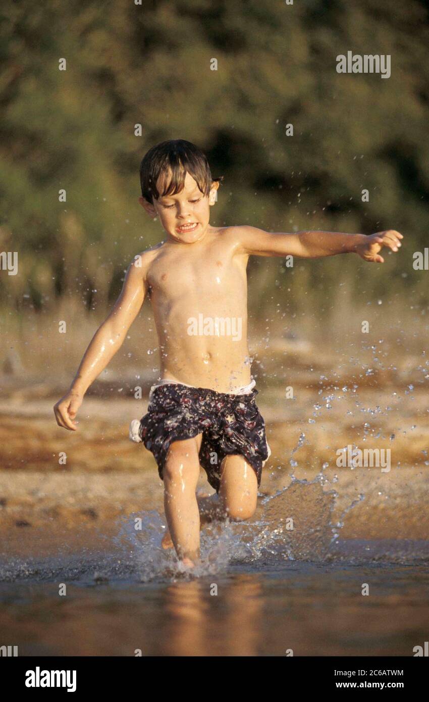 Burnet County Texas, USA, Juli 2005: Der 9-jährige Anglo Boy spielt im Sommer am Ufer des Lake Buchanan in Zentral-Texas. ©Bob Daemmrich Stockfoto