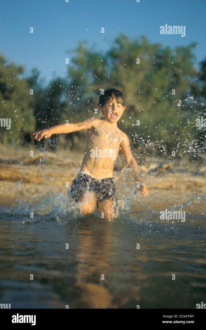 Burnet County Texas, USA, Juli 2005: Der 9-jährige Anglo Boy spielt im Sommer am Ufer des Lake Buchanan in Zentral-Texas. ©Bob Daemmrich Stockfoto