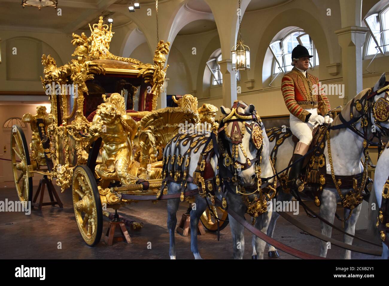Der Gold State Coach wird im Royal Mews am Buckingham Place ausgestellt. Eine verzierte, vergoldete, umschlossene acht Pferdekutsche in den königlichen Ställen. Stockfoto