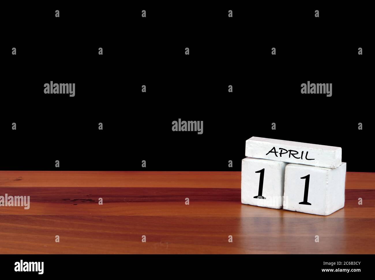 11 April Kalendermonat. 11 Tage im Monat. Reflektierter Kalender auf Holzboden mit schwarzem Hintergrund Stockfoto