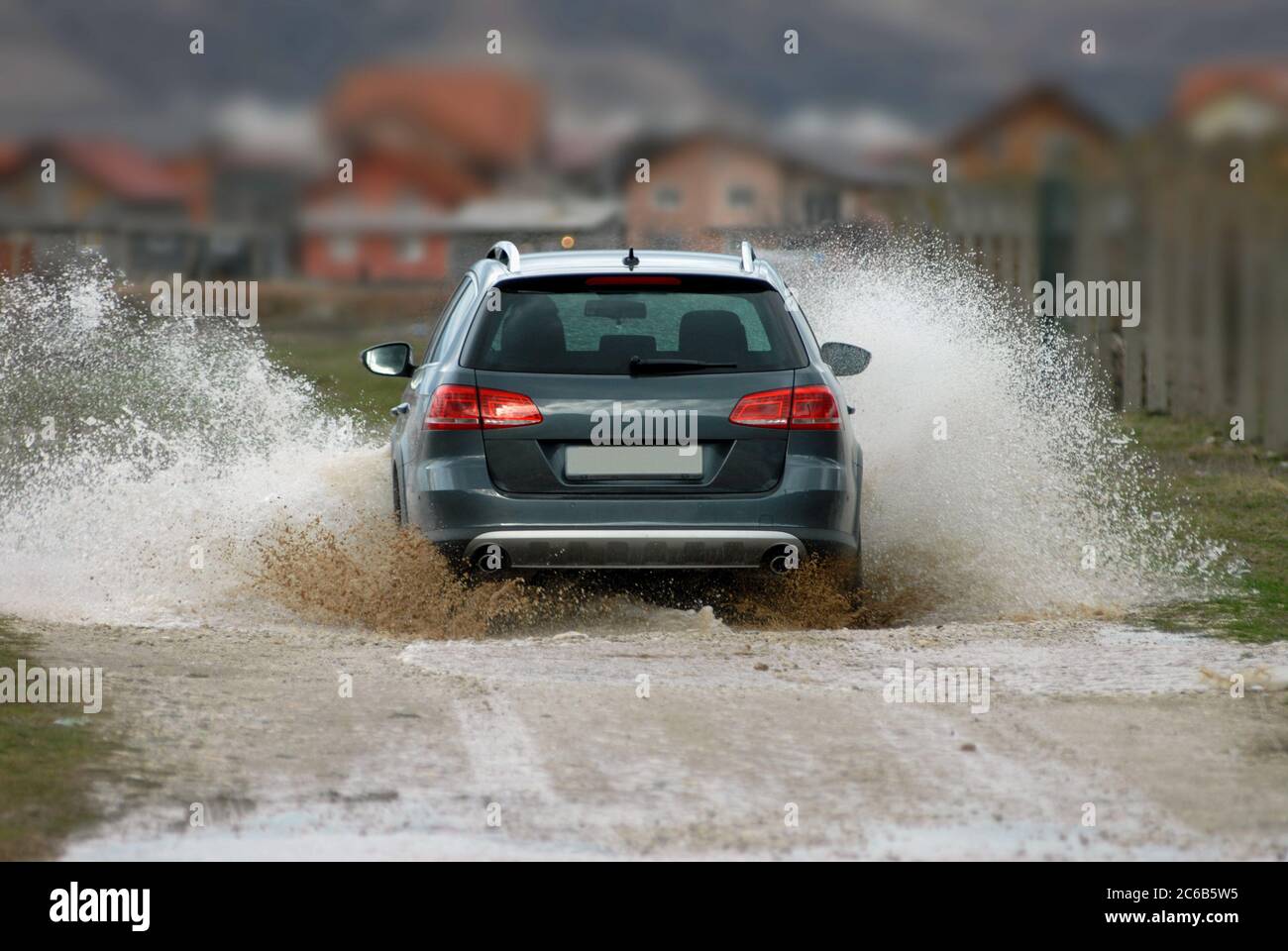 Auto fährt durch überflutete Straße Stockfoto