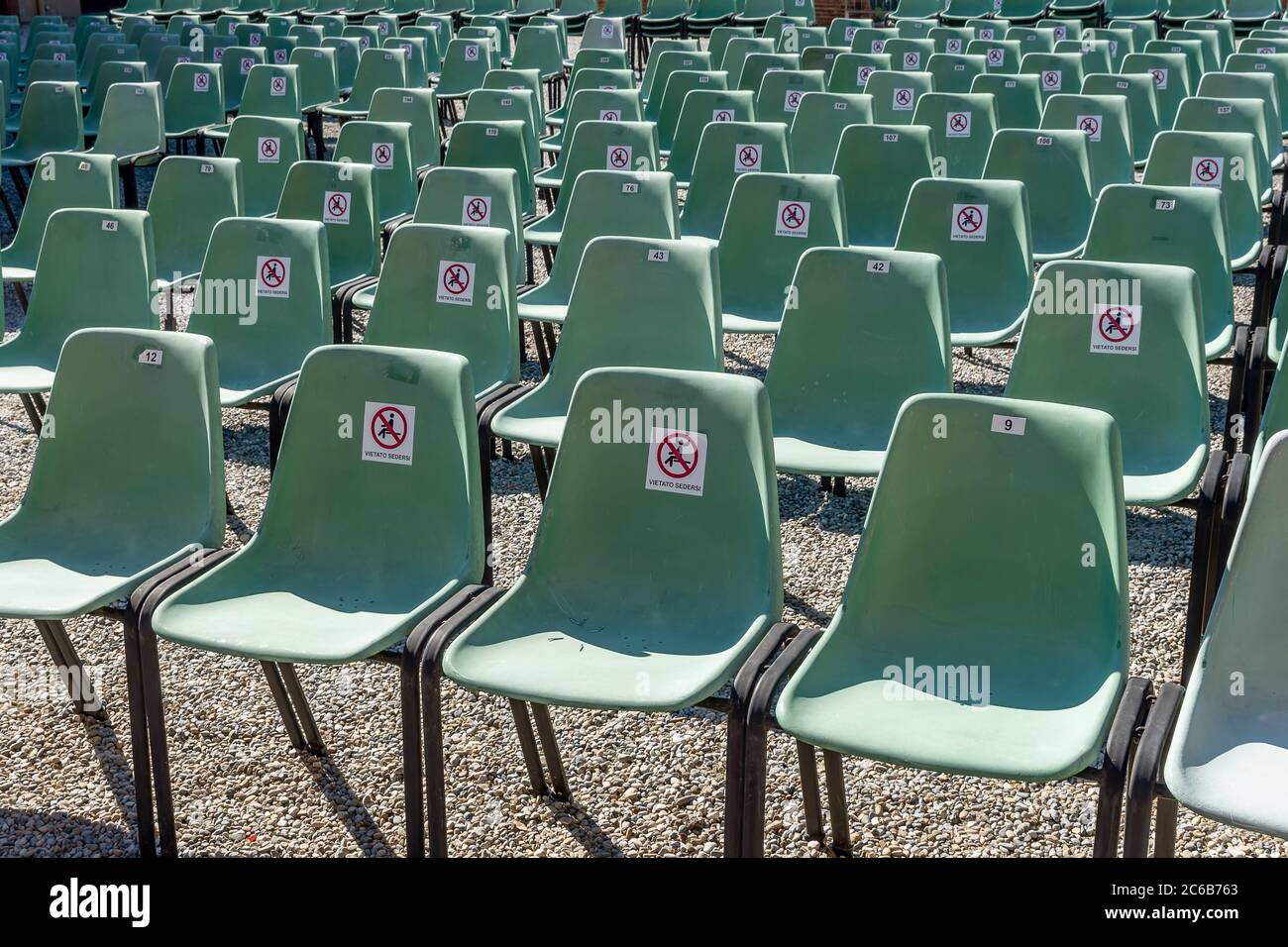 Soziale Distanzierung mit Stühlen, auf denen die italienischen Wörter "vietato sedersi", die "verboten zu sitzen", wegen des Coronavirus covid-19 bedeuten, Stockfoto