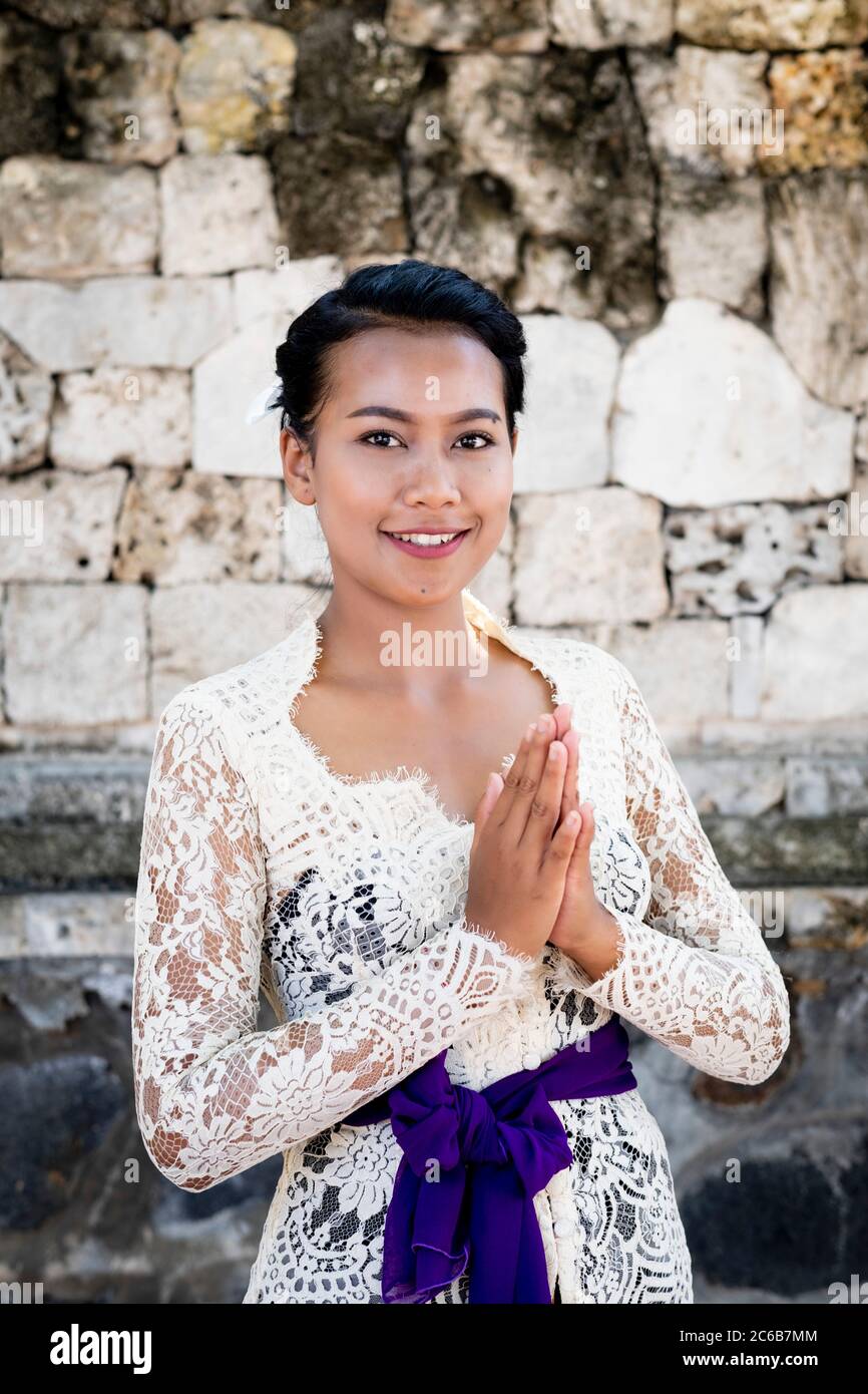 Eine junge Balinesin in einem lokalen Tempelkleid, die einen formalen Gruß und Lächeln macht, Bali, Indonesien, Südostasien, Asien Stockfoto