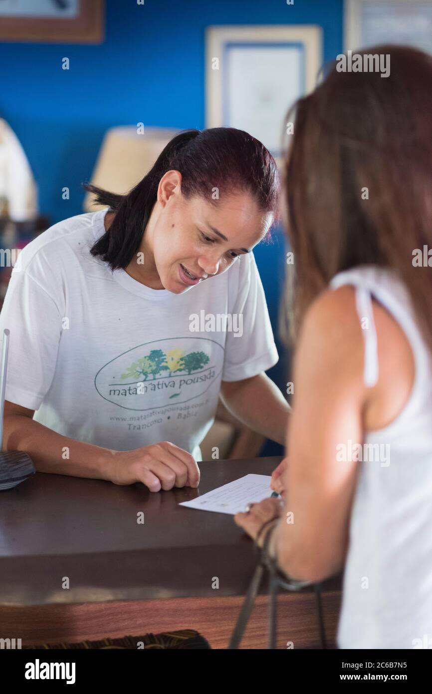 Eine Frau, die in ein Hotel in Bahia, Trancoso, Bahia, Brasilien, Südamerika eincheckt Stockfoto