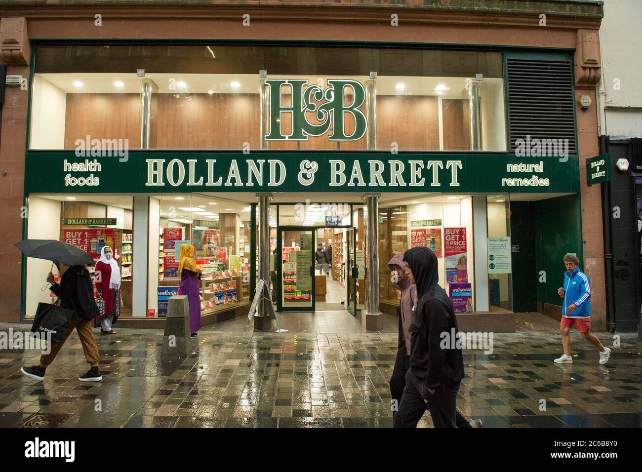 Glasgow, Schottland, Großbritannien. Juli 2020. Im Bild: Menschen im Regen einkaufen im Stadtzentrum von Glasgow Da die Sperre des Coronavirus (COVID19) nachgelassen hat, werden die Menschen ab diesem Freitag, den 10. Juli, eine Gesichtsbedeckung tragen müssen, wenn sie in ein Geschäft gehen, um die Ausbreitung des Coronavirus zu stoppen. Quelle: Colin Fisher/Alamy Live News Stockfoto