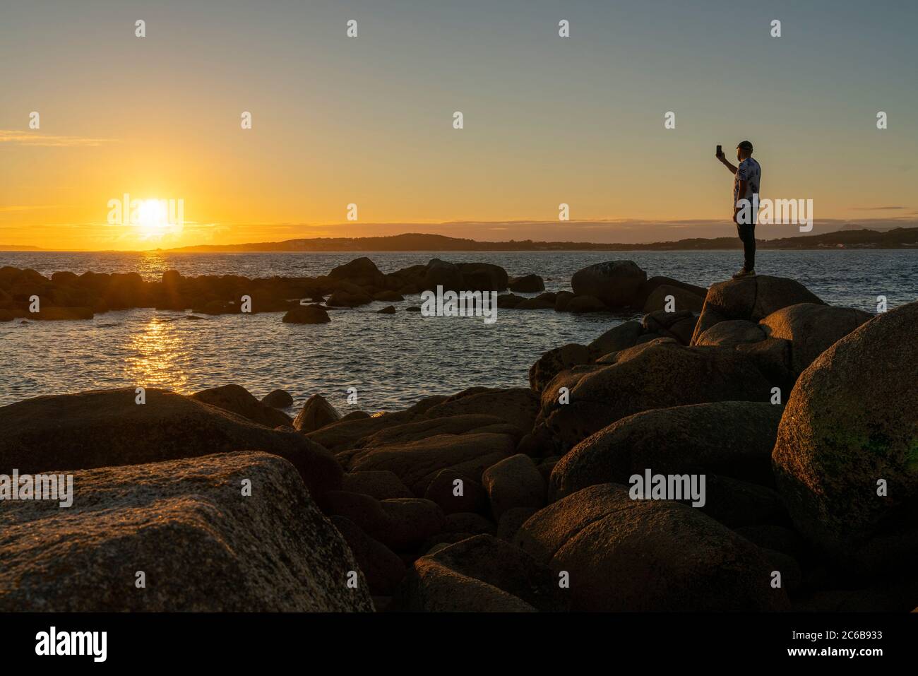 Person, die ein Foto am Strand von La Lanzada macht, Galizien, Spanien, Europa Stockfoto