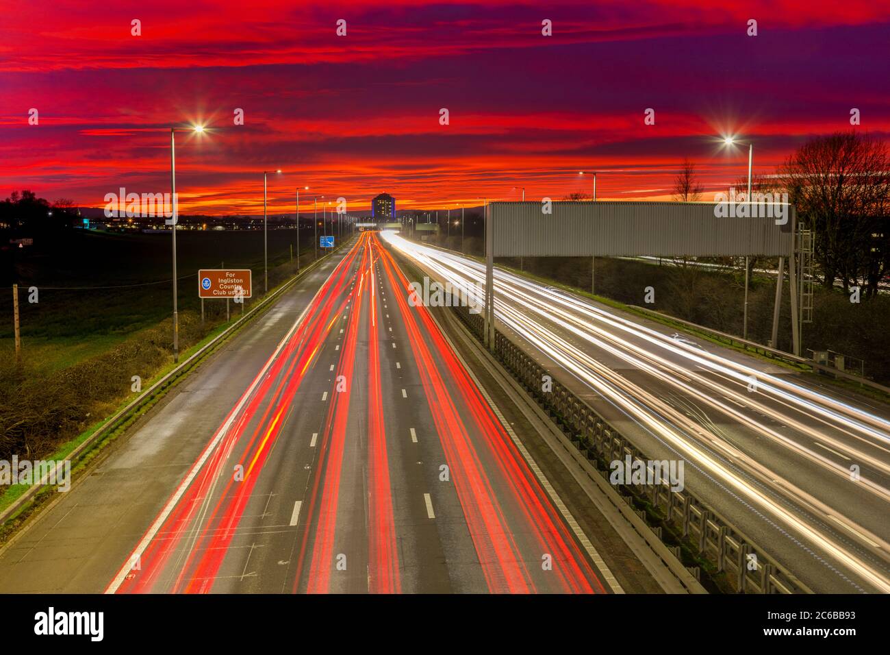 Sonnenuntergang am roten Himmel, Ampelwege, M8 Autobahn, Schottland, Großbritannien, Europa Stockfoto