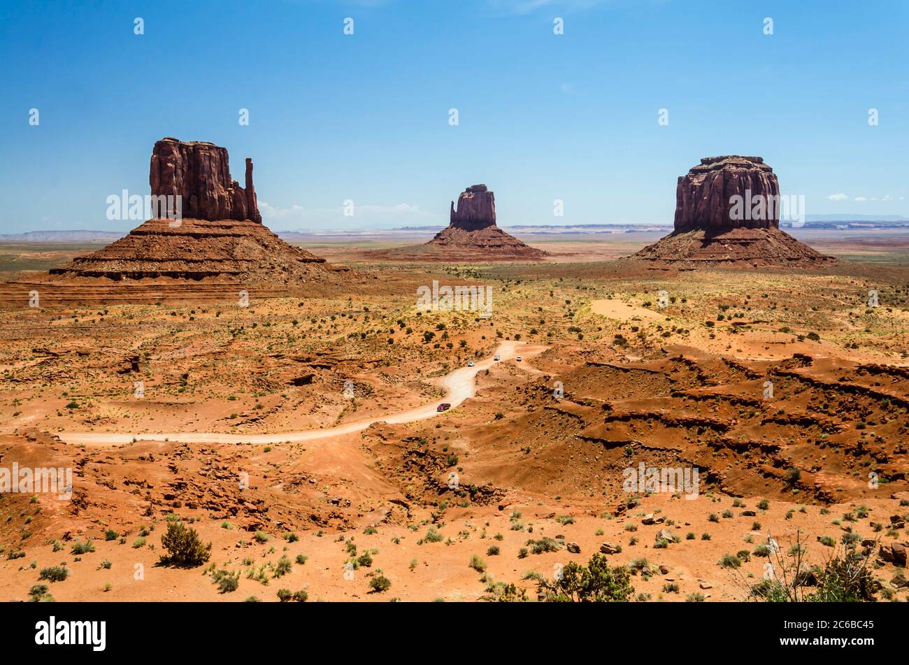 Unbefestigte Straße mit Autos und mesa Berge in Monument Valley Stockfoto
