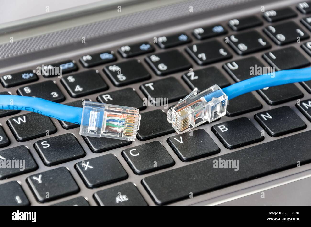 Zwei Internetkabel auf einer Computertastatur symbolisieren Verbindungsprobleme Stockfoto