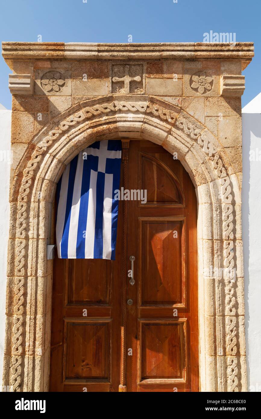 Unter dem Steinbogen hängt eine griechische Flagge in der Tür eines Kapitäns von Lindos auf Rhodos, Dodekanes, griechischen Inseln, Griechenland, Europ Stockfoto Unter dem Steinbogen hängt eine griechische Flagge in der Tür eines Kapitäns von Lindos auf Rhodos, Dodekanes, griechischen Inseln, Griechenland, Europ Stockfoto