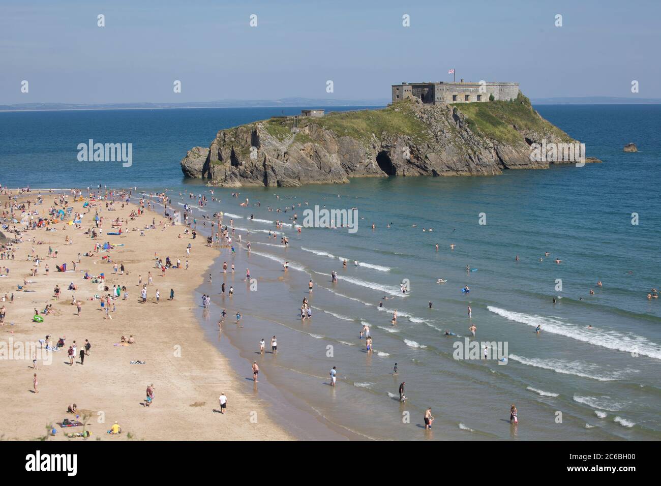 Tenby Beach, Pembrokeshire, Wales. An einem heißen Tag ist der Strand voll. Sommerspaß, schöner Strand, landschaftlich schöner Strand, Tourismus, Aufenthalt, Schönheitsplätze, Festung, Insel Stockfoto
