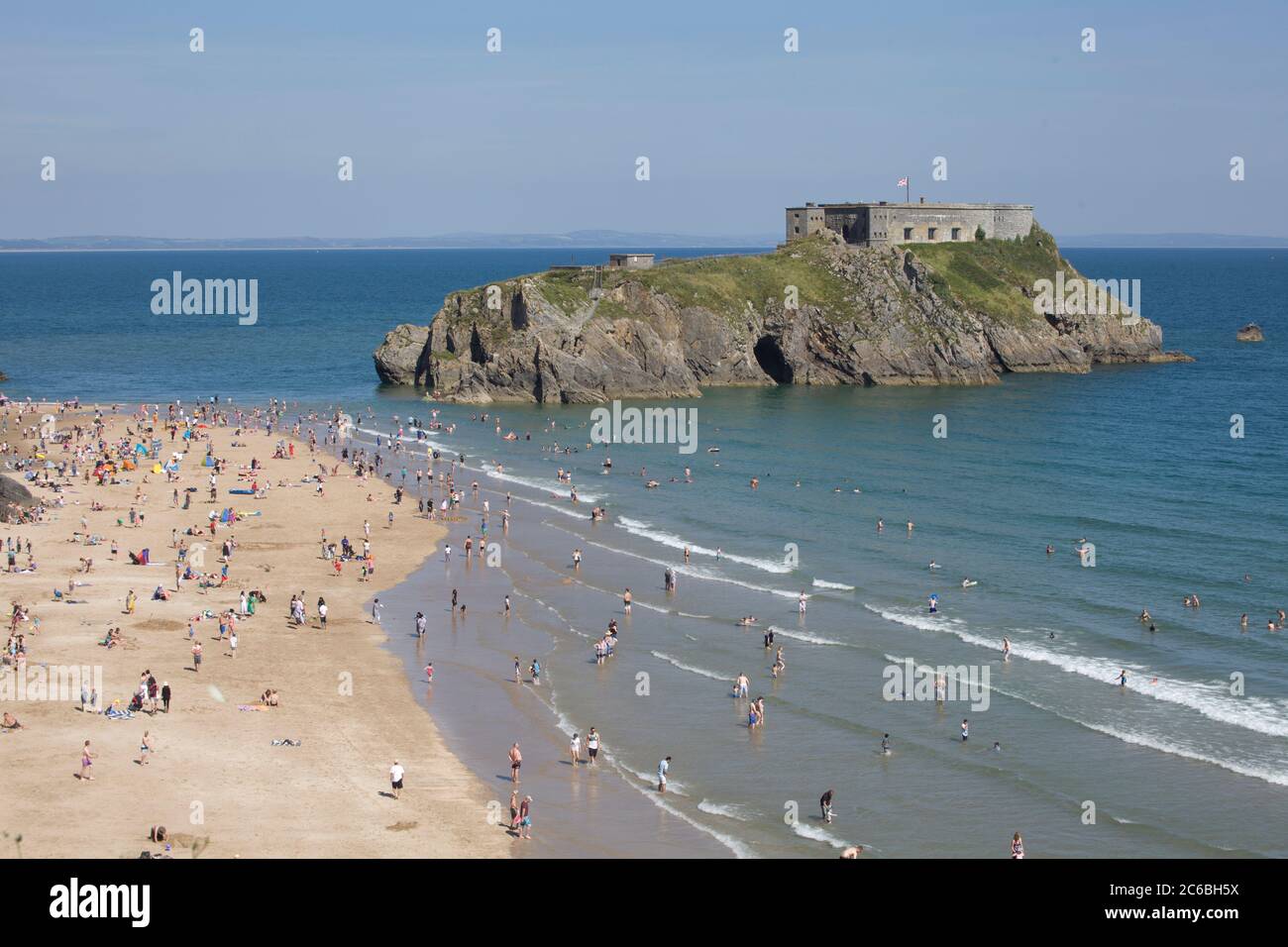 Tenby Beach, Pembrokeshire, Wales. An einem heißen Tag ist der Strand voll. Sommerspaß, schöner Strand, landschaftlich schöner Strand, Tourismus, Aufenthalt, Schönheitsplätze, Festung, Insel Stockfoto