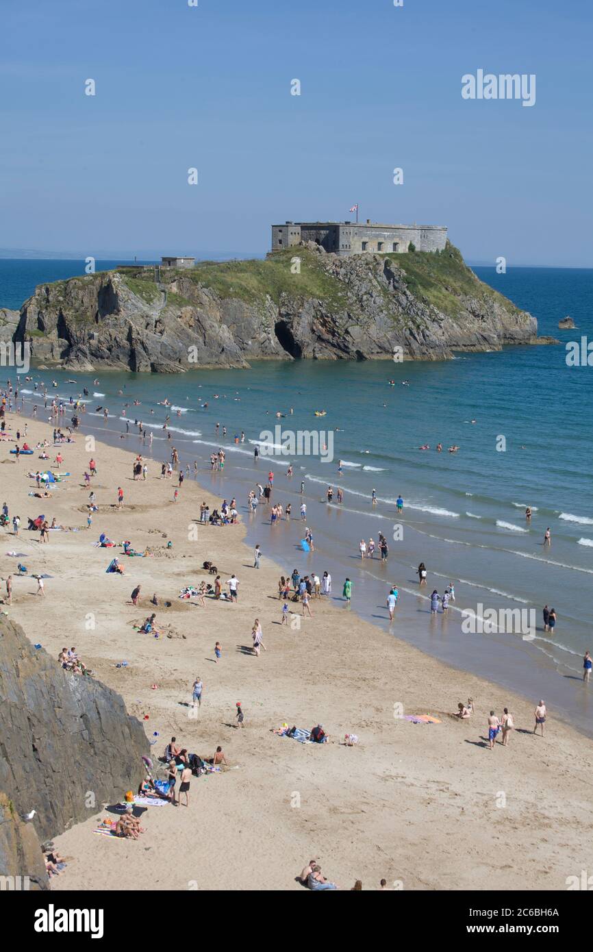 Tenby Beach, Pembrokeshire, Wales. An einem heißen Tag ist der Strand voll. Sommerspaß, schöner Strand, landschaftlich schöner Strand, Tourismus, Aufenthalt, Schönheitsplätze, Festung, Insel Stockfoto