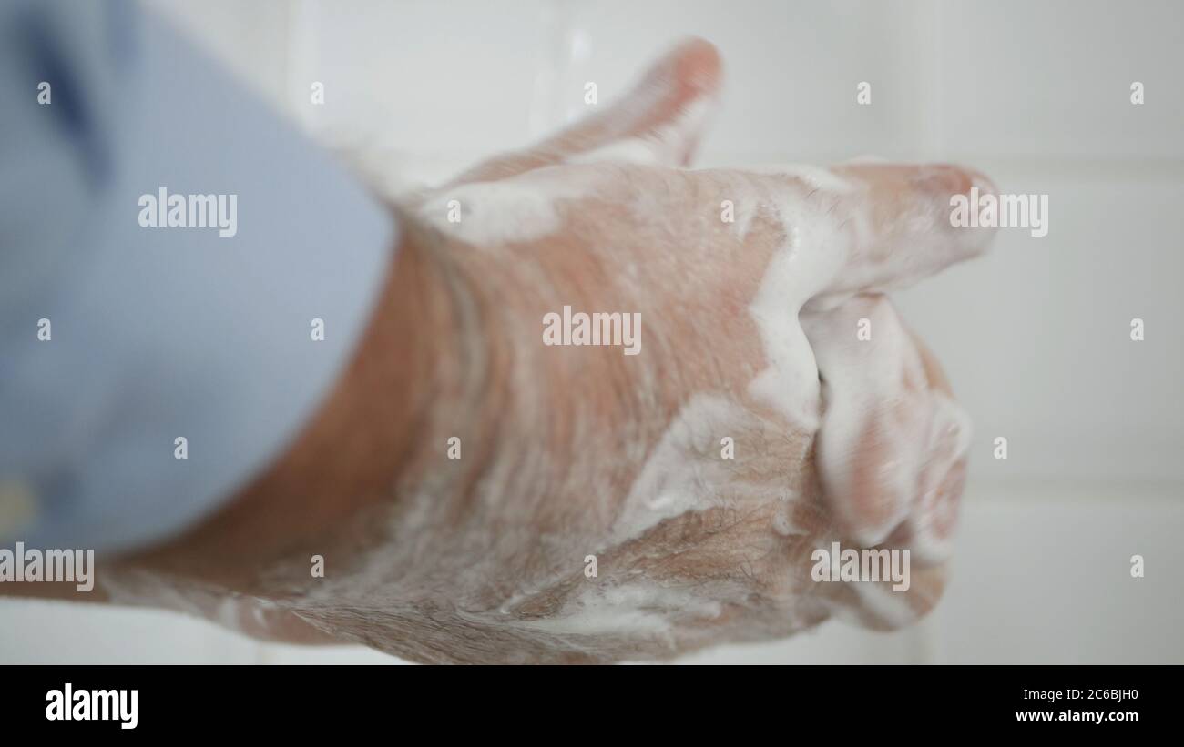 Person, die seine Hände mit Seife und Wasser wäscht, reinigt und desinfiziert gegen Viren und Krankheiten Stockfoto