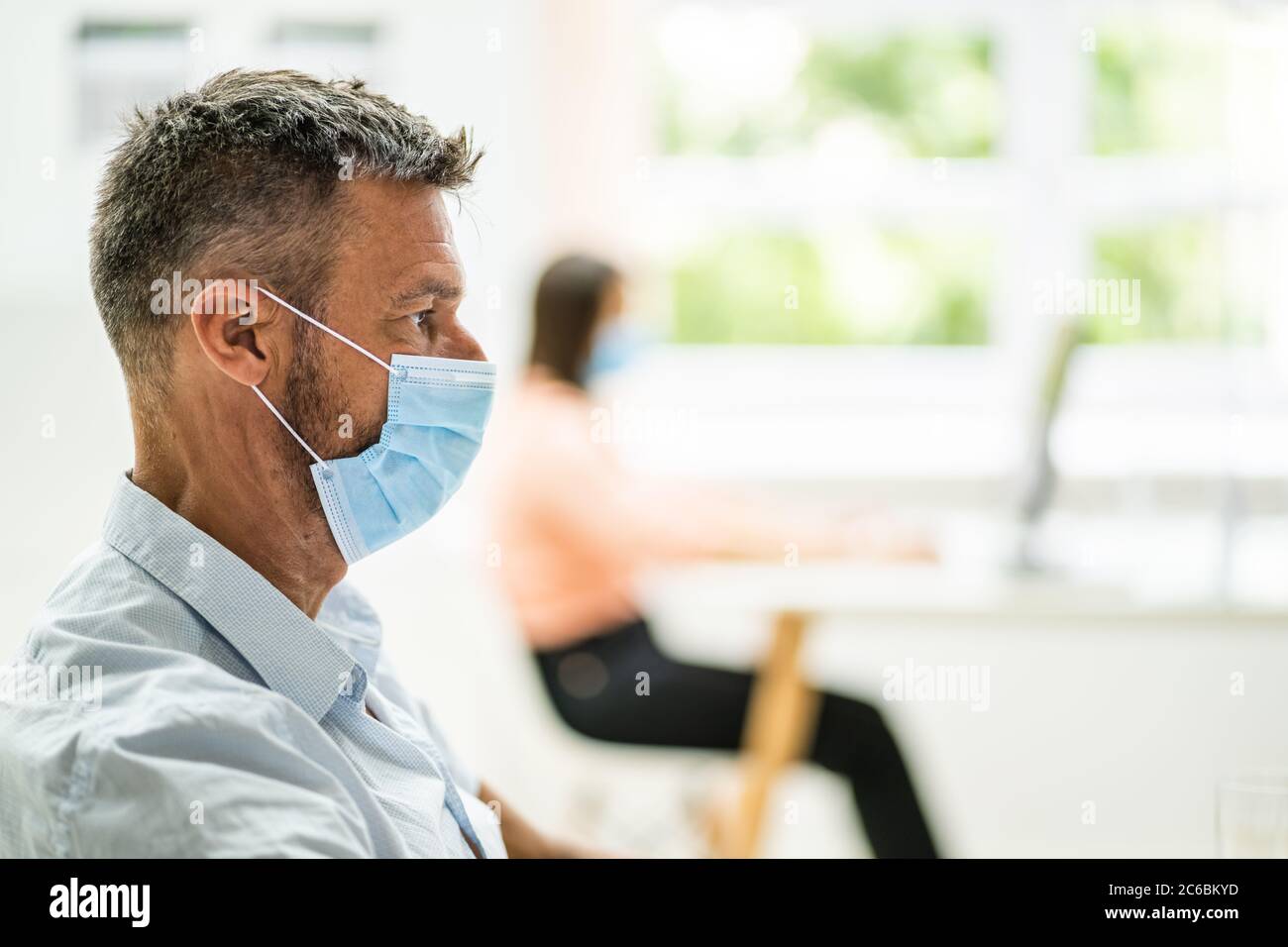 Ältere Männliche Arbeiter Im Büro Trägt Medizinische Gesichtsmaske Stockfoto