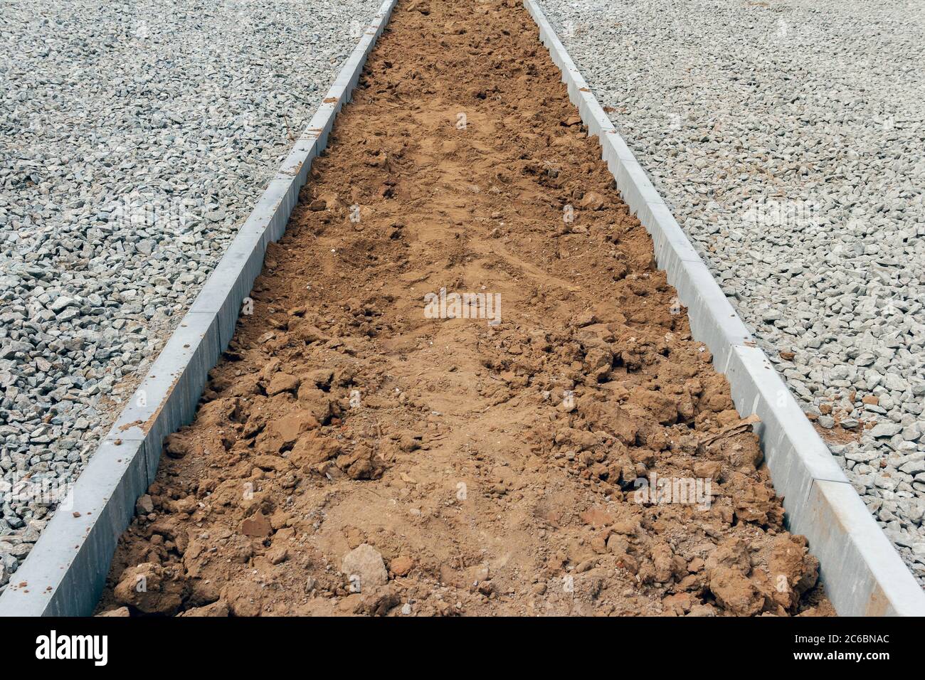 Die Verbesserung der Straße. Die Basis der Straße ist Kies und ein Platz für eine Wiese. Richten Sie ein Gebiet ein Stockfoto