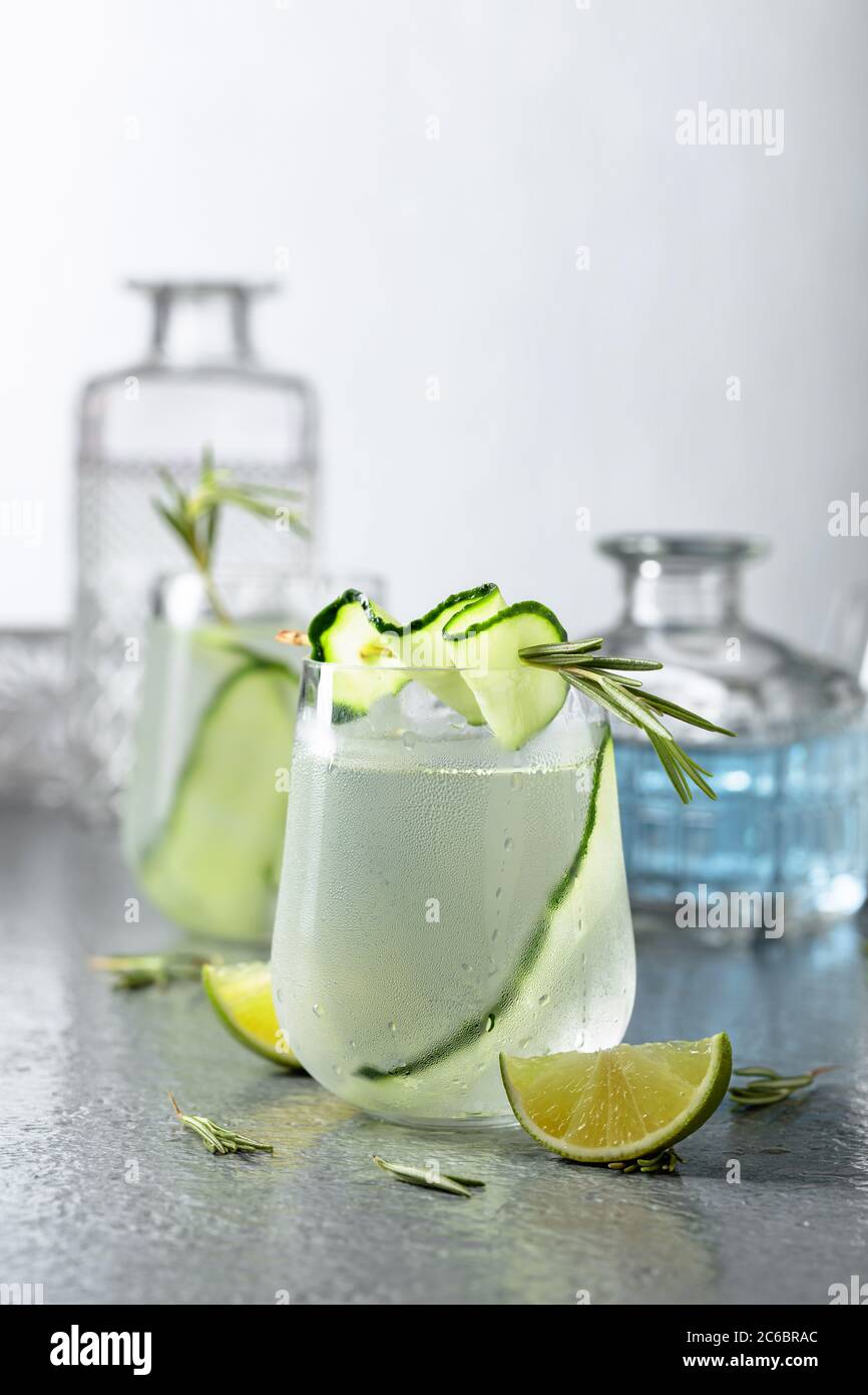 Gin Tonic mit Rosmarin, Limette und Gurke in Milchglas. Cocktail auf einem grauen Metalltisch. Stockfoto