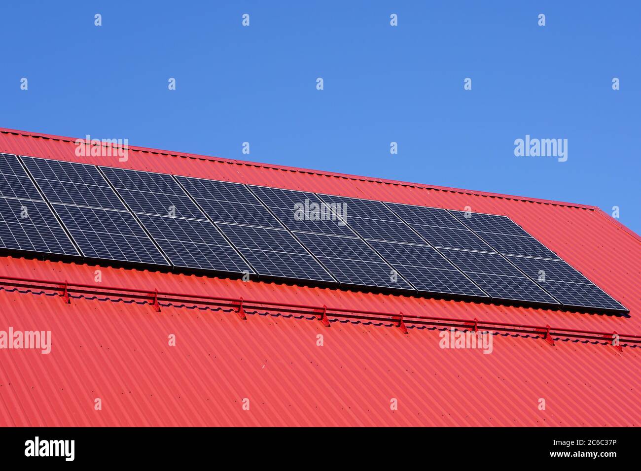 Solarzellen auf einem roten Dach des modernen Hauses Stockfoto