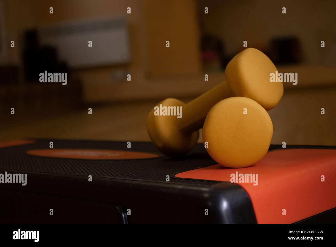 Gelbe kleine Hanteln auf der Trittplattform im Fitnessstudio. Sportkonzept. Hochwertige Fotos Stockfoto