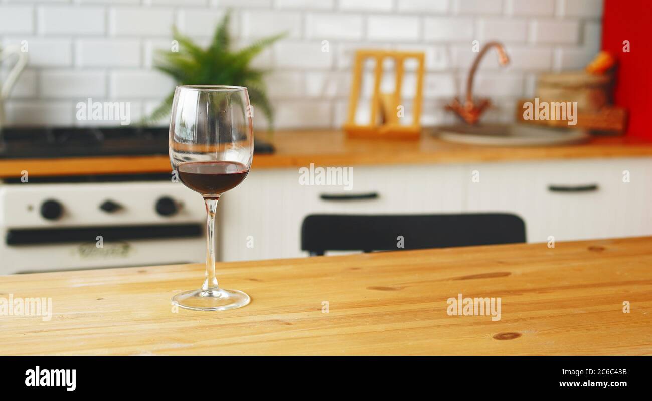 Nahaufnahme eines Glases Wein auf dem Tisch in der Küche. Stockfoto