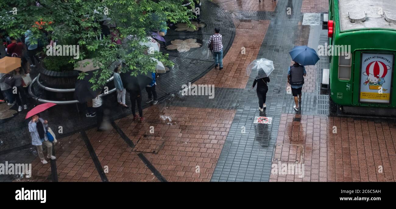 Menschen auf Shibuyas Hachiko-Platz mit Regenschirm an einem regnerischen Tag, Tokio, Japan Stockfoto