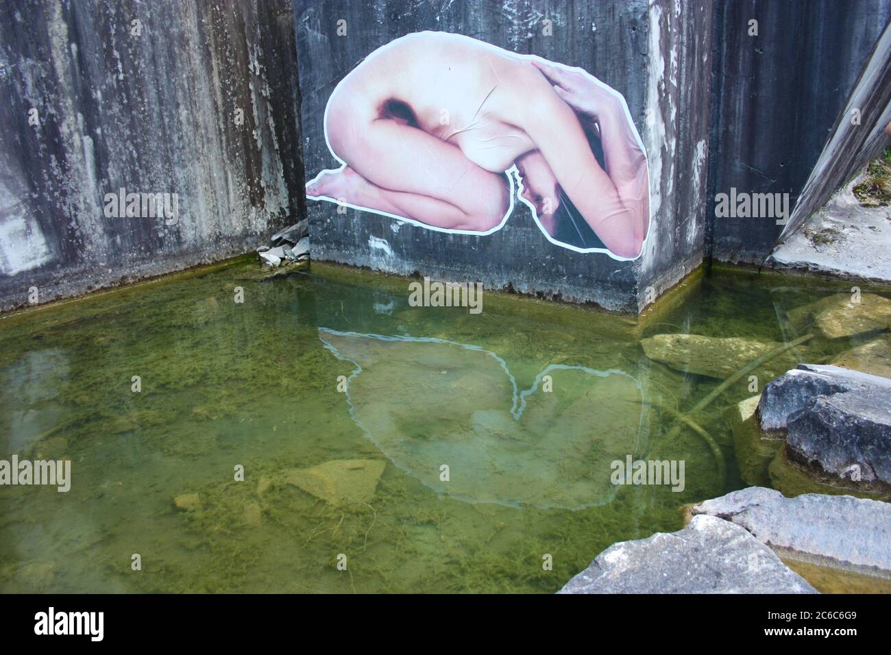 Aufkleber einer knienden Frau an der Wand eines verlassenen Marmorbruchs in der toskana Wahrzeichen angebracht Stockfoto