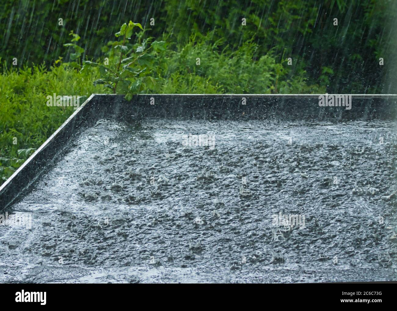 Starker Regen auf einem schwarzen Flachdach Stockfoto