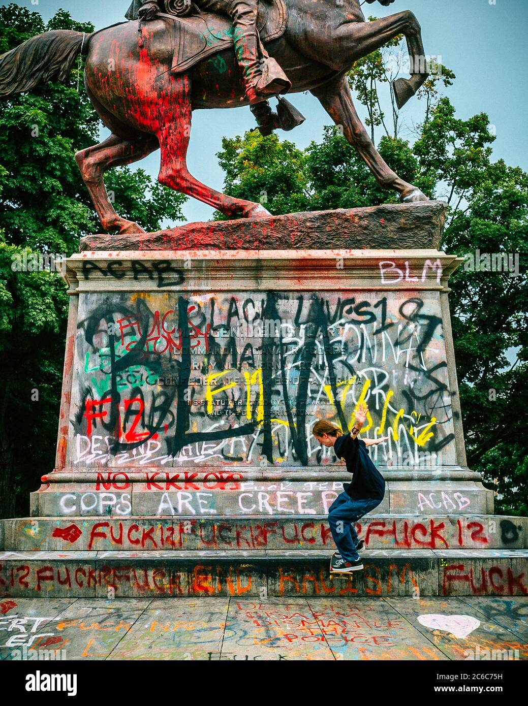 Ein Mann reitet auf dem mit Graffiti bedeckten J.E.B. ein Skateboard Stuart Monument of Monument Avenue in Richmond, Virginia Stockfoto