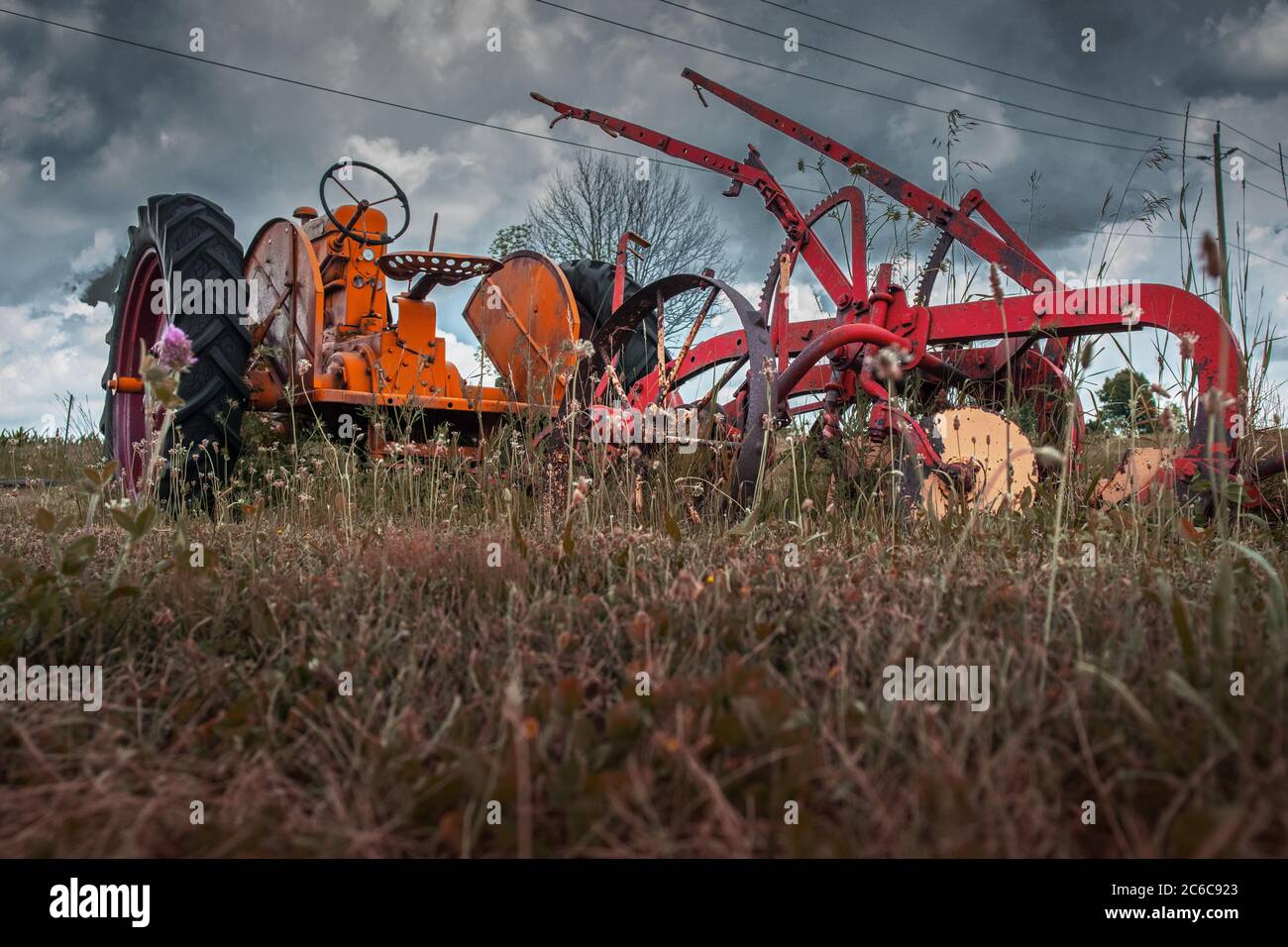 Ein Oldtimer-Traktor und sein Pflug auf einem Trockenland verlassen. Stockfoto