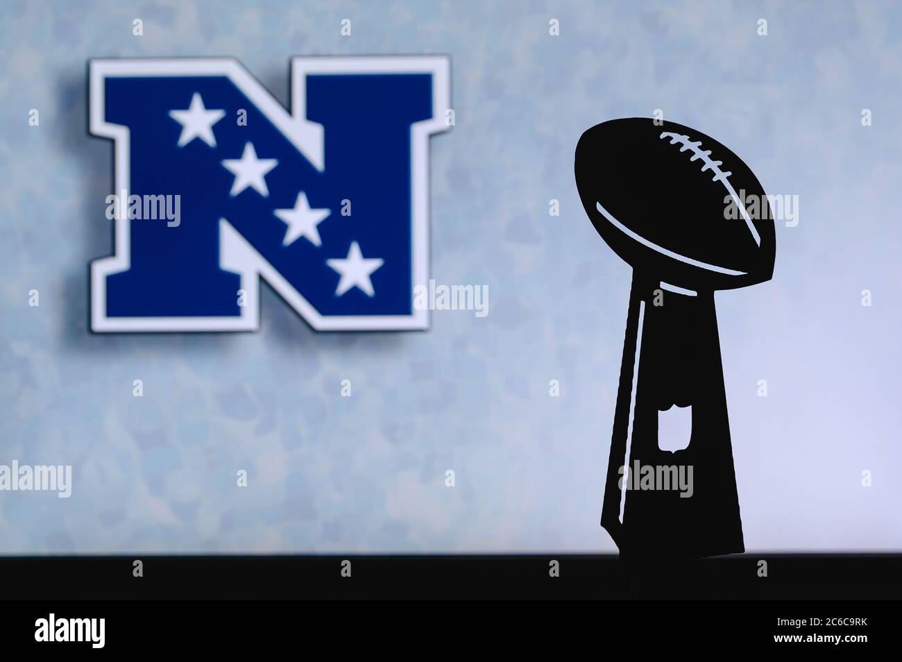 National Football Conference – NFC, professioneller amerikanischer Fußballverein, Silhouette der NFL-Trophäe, Logo des Vereins im Hintergrund. Stockfoto