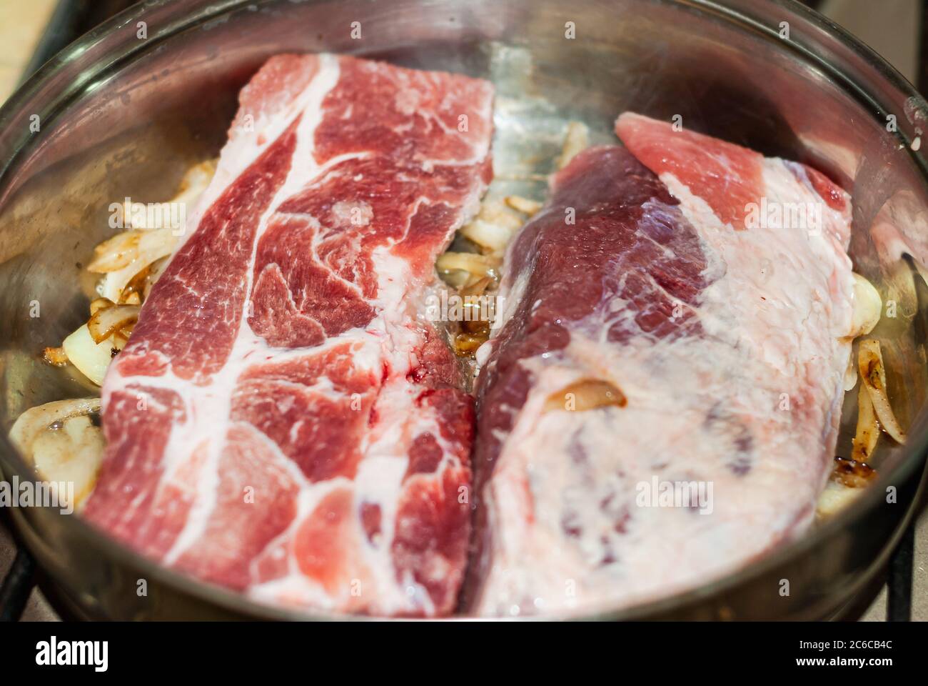 Rindersteaks in der Pfanne mit Zwiebeln, Andenkartoffeln, feinen Kräutern und Gewürzen gekocht. Stockfoto